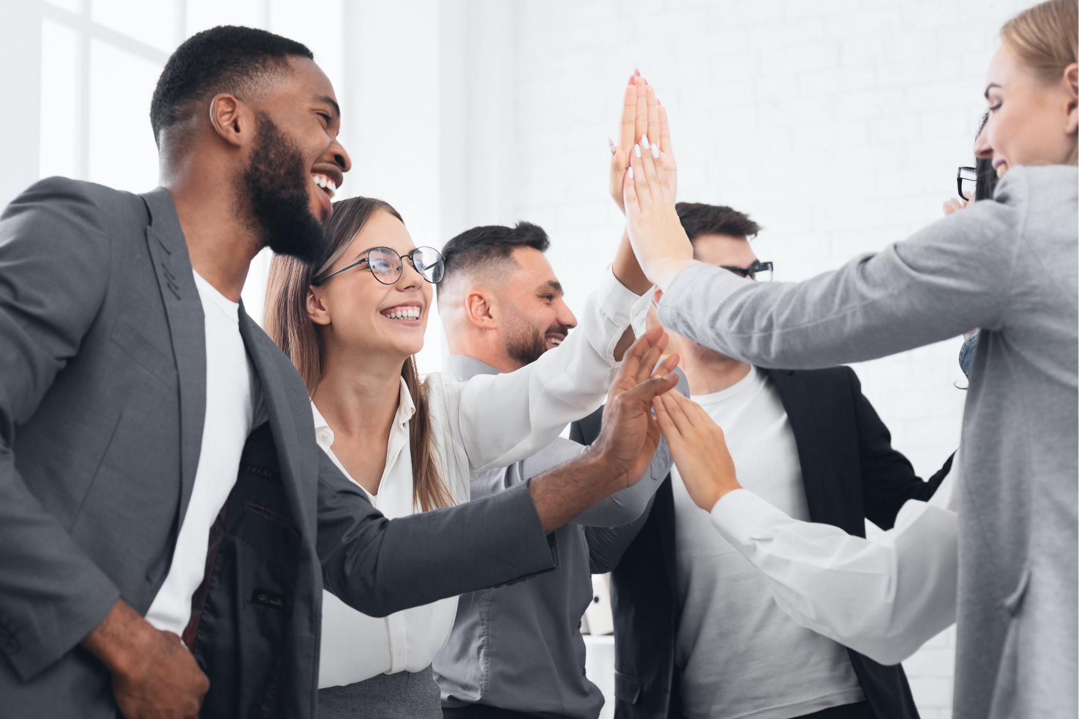 happy group of team members high fiving