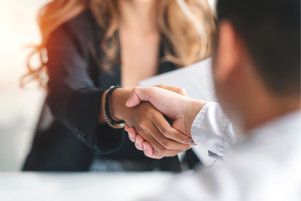 Close-up of a handshake between two professionals, symbolizing a successful agreement, emphasizing the benefits of printer leasing solutions.